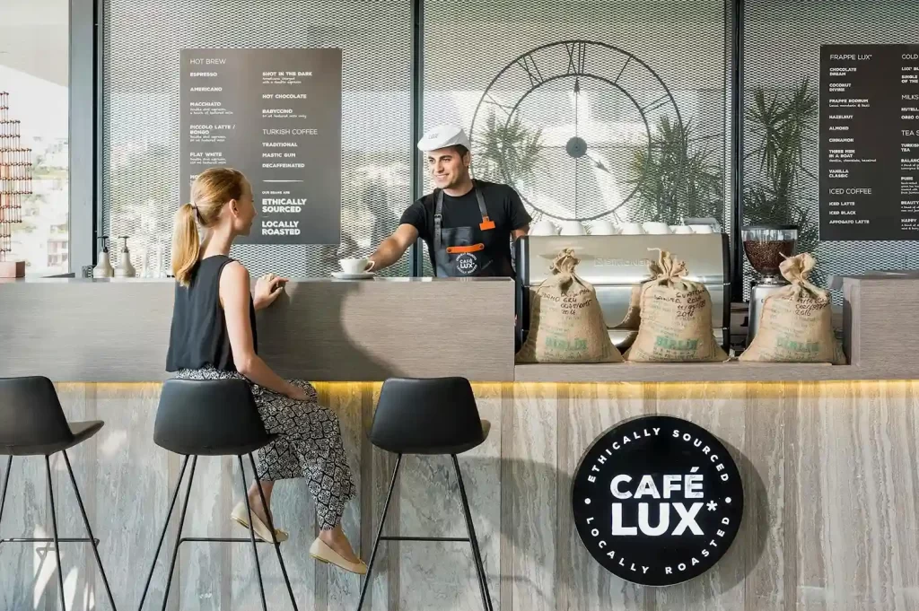 Barra de café de especialidad con barista atendiendo cliente en Bogotá.