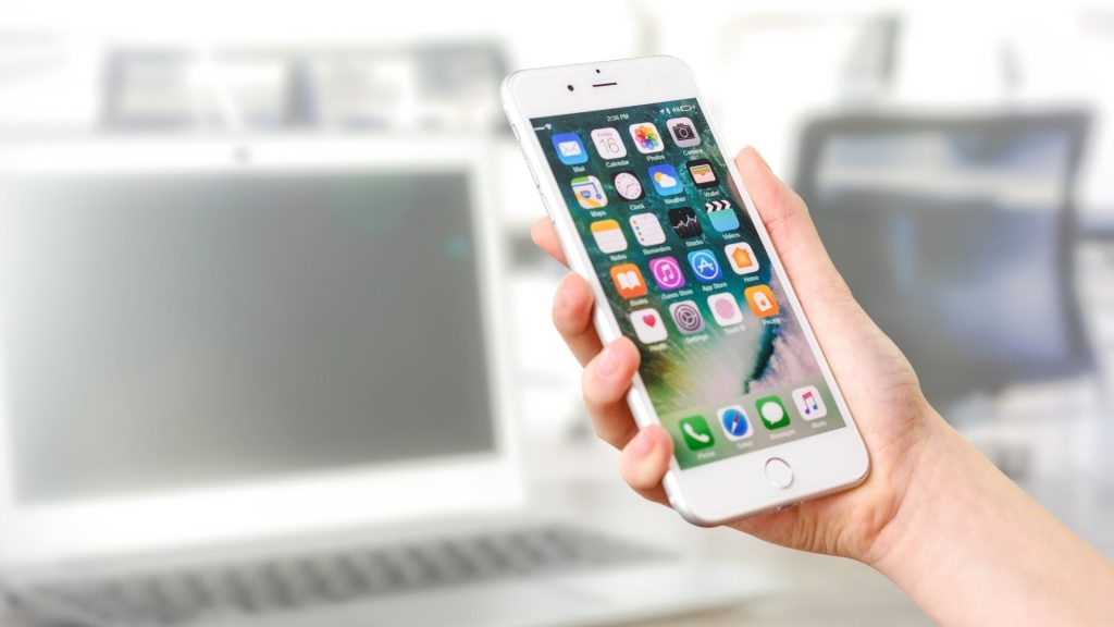 Persona usando smartphone para gestionar servicios y experiencias durante su primera semana en una residencia de lujo con Vezra