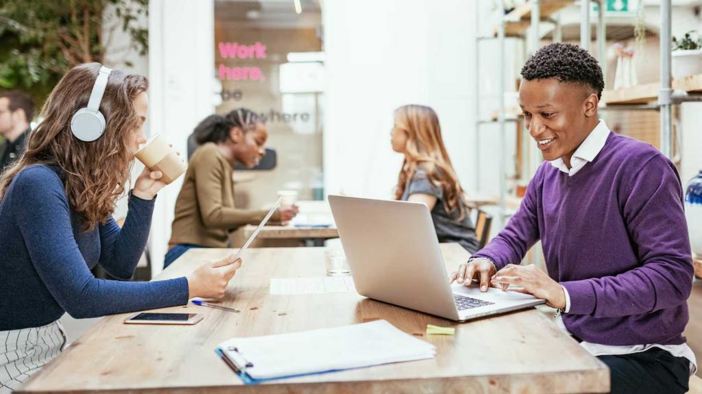 Personas trabajando en espacio de coworking moderno y premium con laptops en ambiente colaborativo cerca de la Zona T en Bogotá