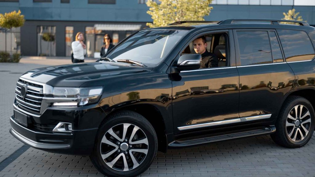 Vehículo de lujo con chofer privado listo para traslado, representando el servicio de concierge y transporte exclusivo en experiencias premium