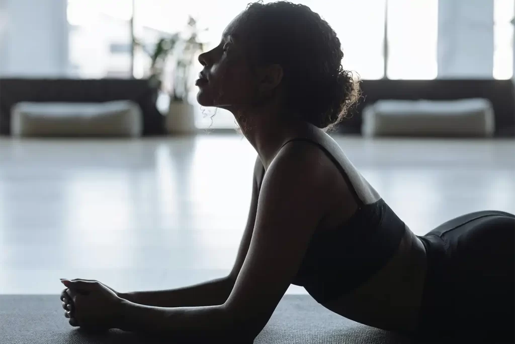 Mujer practicando yoga en el gimnasio privado de un apartamento de lujo en Bogotá con iluminación natural.