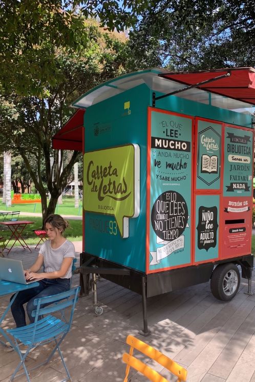Nómada digital trabajando en el Parque de la 93 en Bogotá, junto a la biblioteca móvil Carreta de Letras.