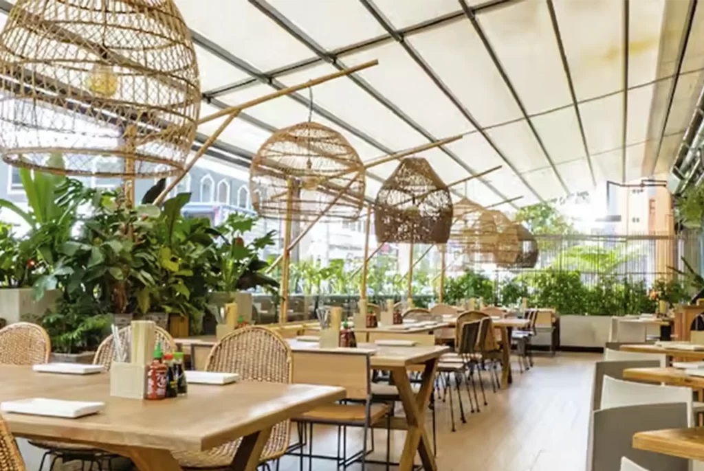 Restaurant with lamps wicker and indoor garden near apartments VEZRA for executives in Bogotá Parque 93.