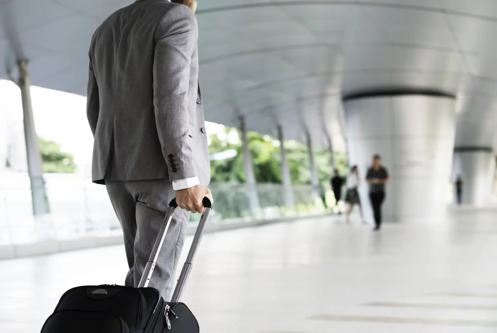 Executive with suitcase in airport and arriving at Bogota, accommodation guide corporate VEZRA for companies.