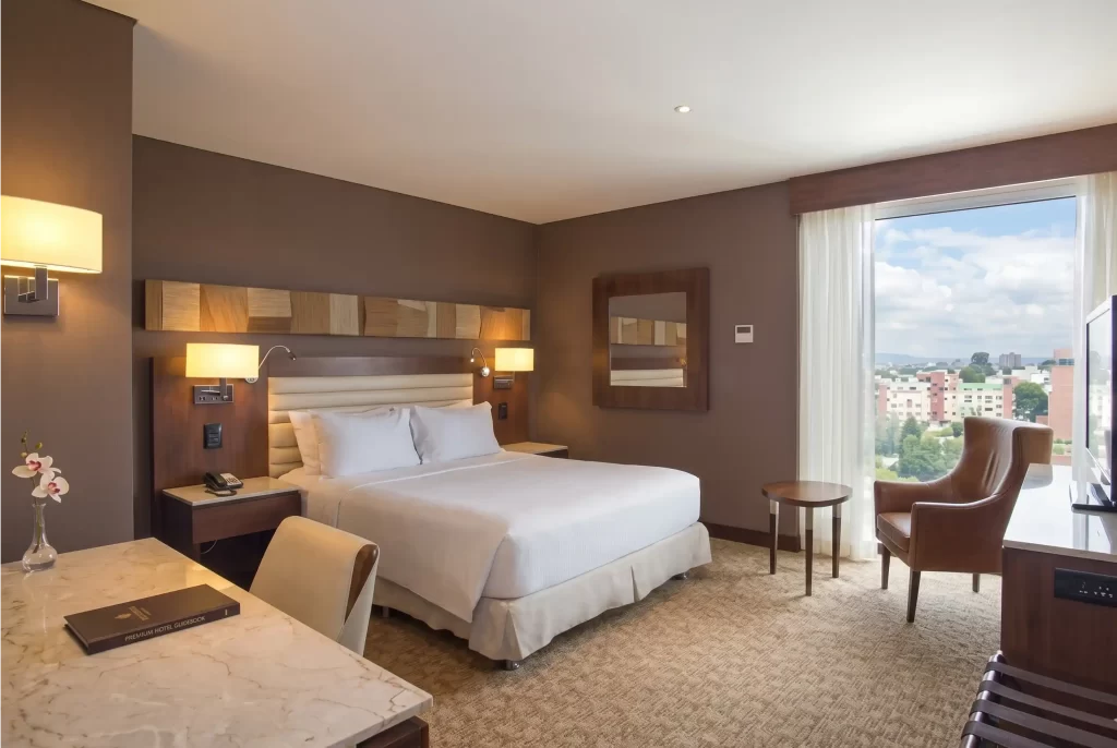 Deluxe hotel room in Bogotá with a king size bed and desk, a comparison with apartment VEZRA in Park 93.