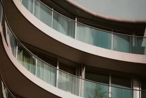 Fachada curva con balcones de vidrio en edificio residencial de lujo en zona Parque 93, apartamentos VEZRA Bogotá.