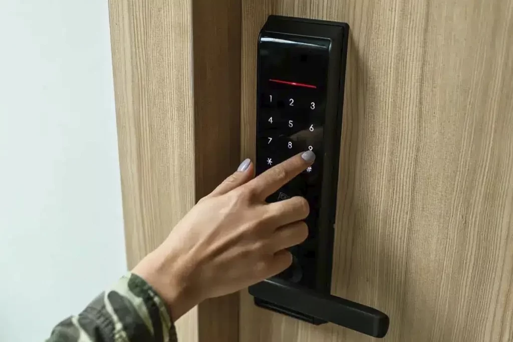 Mano ingresando código en cerradura digital negra en puerta de residencia en Bogotá