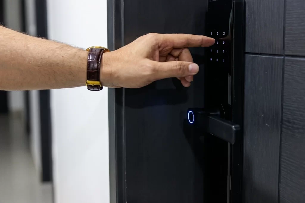 Mano ingresando código en cerradura digital de puerta en residencia ejecutiva.