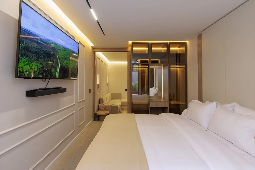 Dormitorio de residencia con cama doble, closet espejado e iluminación cálida en Bogotá.